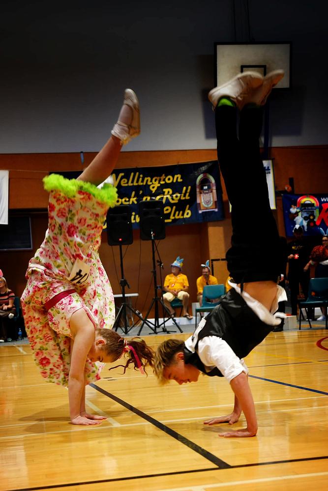 Shelby and Caleb caught in the midst of a cartwheel/round-ff